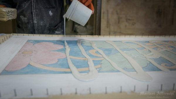 New glue is applied on the negative side of the fresco to transfer it to positive